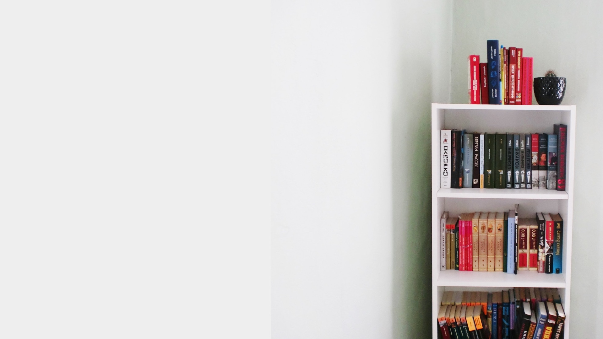 小さい本棚と薄いグレーの壁の無料バーチャル背景素材