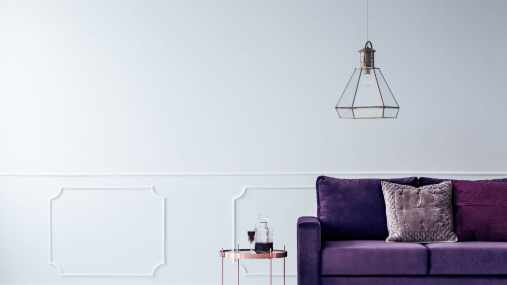 紫のソファーのある白い壁の部屋